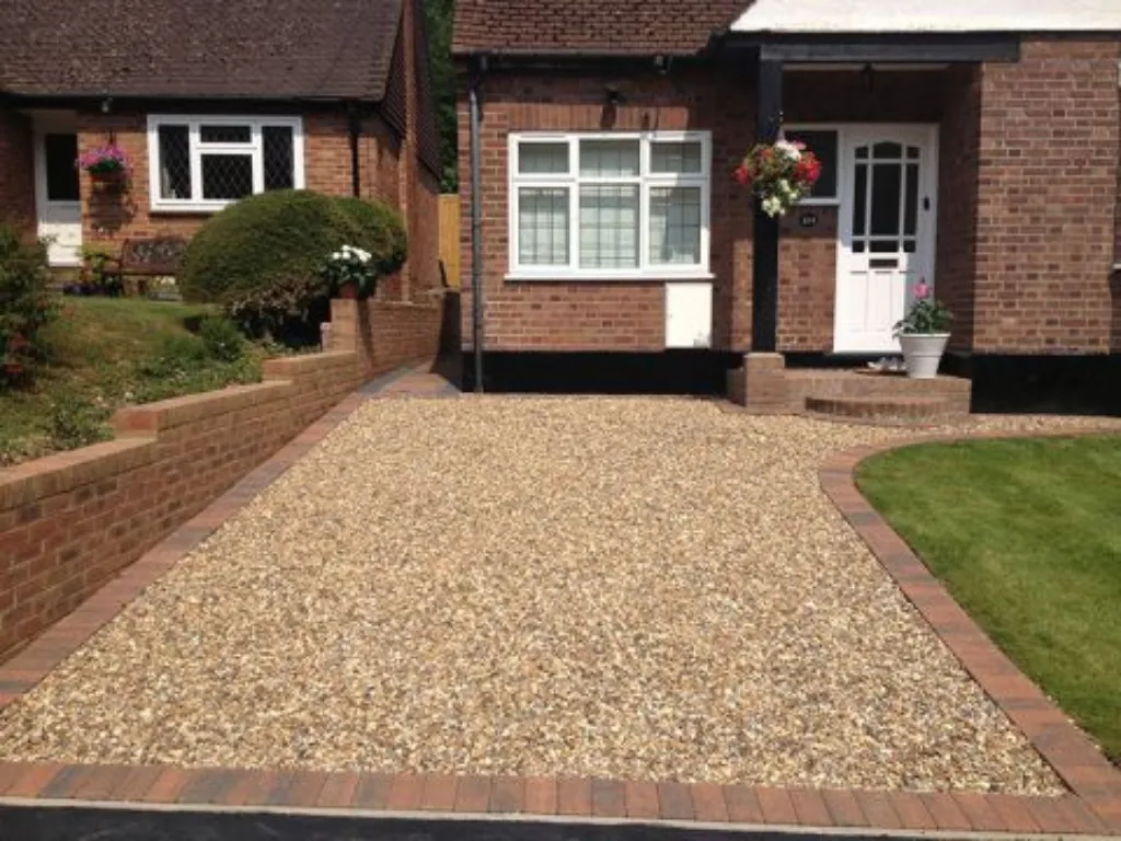Driveways Company in Hertfordshire gravel driveway installation with block paving border in front of a brick house
