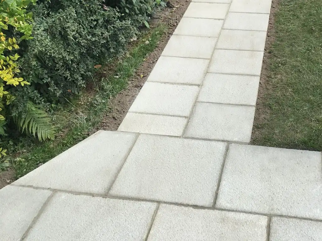 Landscaping Company in Hertfordshire building a modern grey stone garden path next to a lawn and green bushes