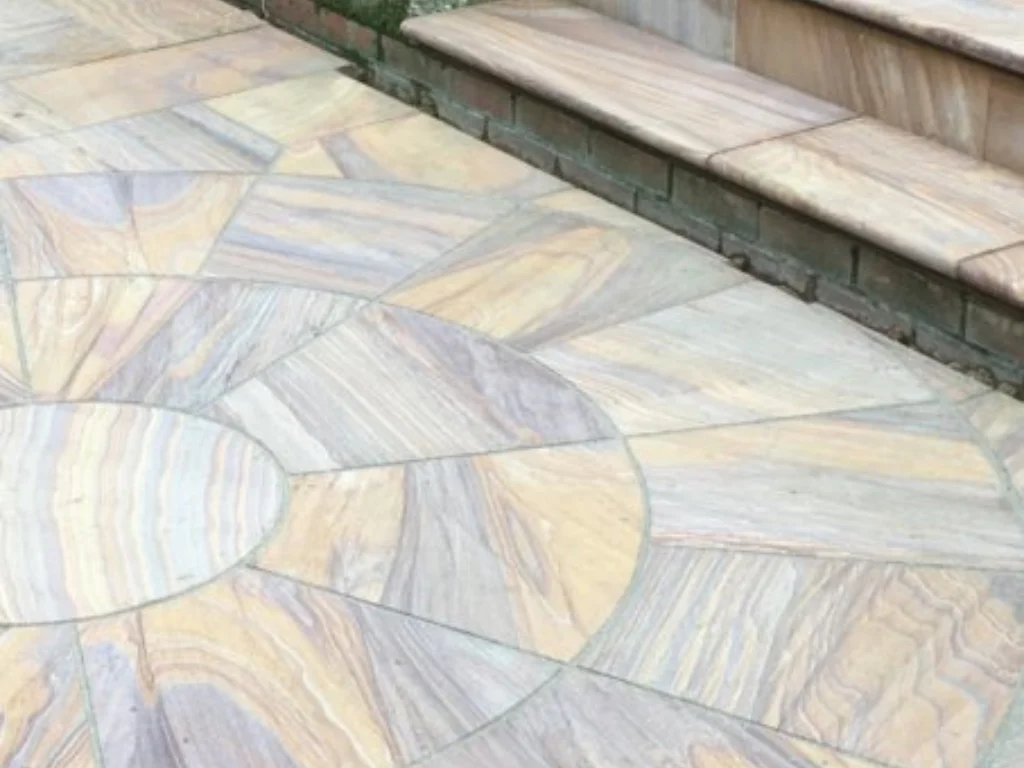 Paving company in Hertfordshire installing a circular indian sandstone patio feature with matching stone steps